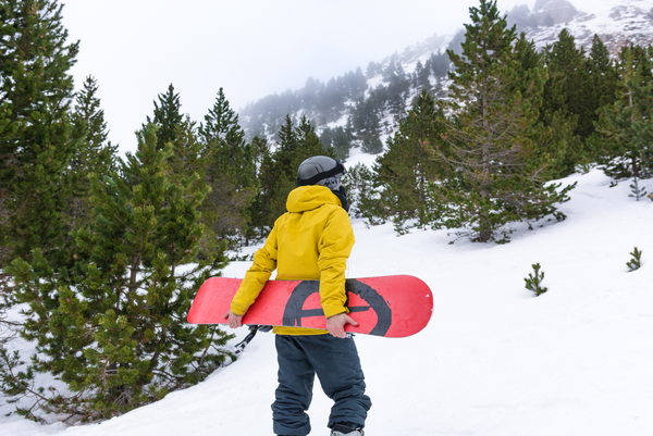 Man holding snowboard on ski slope