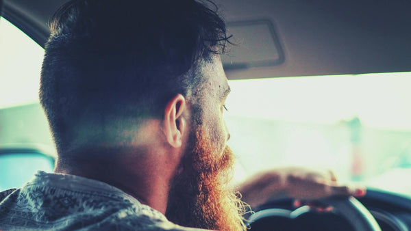 Bearded man driving car
