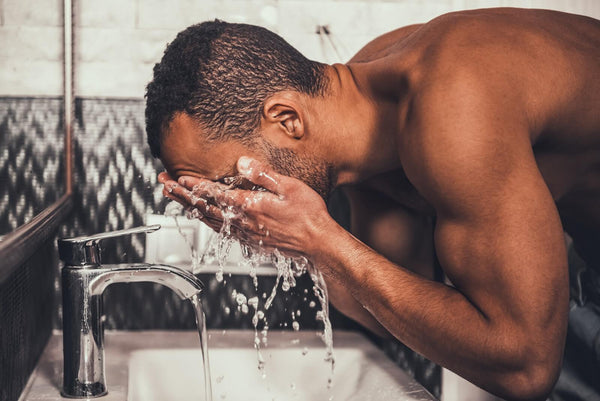 Man washing face in sink